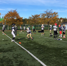 Auringossa kylpevä Velodromin ulkokenttä ja taklausharjoittelua.