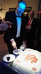 Puheenjohtaja Robert Hotanen leikkaa juhlakakkua.